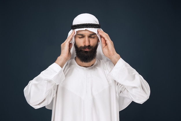 Бесплатное фото Мужчина из саудовской аравии на синей стене