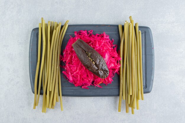 Sauerkraut and pickled eggplants on black board.  