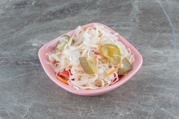 Sauerkraut. Shredded cabbage and carrots in pink bowl. 