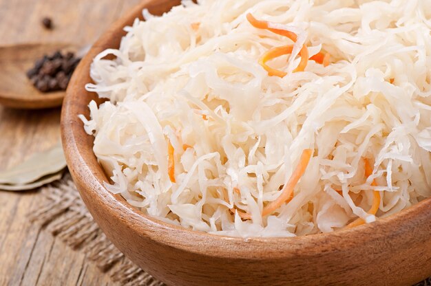 Sauerkraut with carrot in wooden bowl