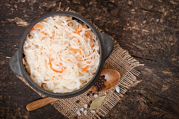 Free Photo sauerkraut with carrot in wooden bowl
