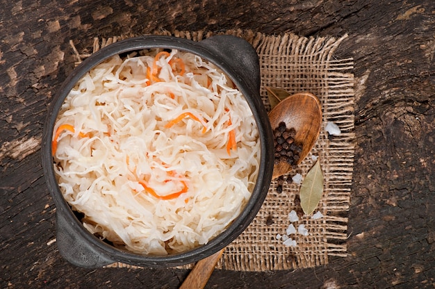 Sauerkraut with carrot in wooden bowl