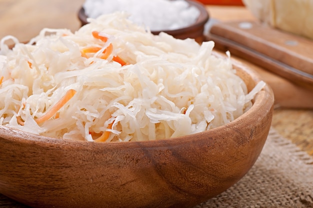 Sauerkraut with carrot in wooden bowl