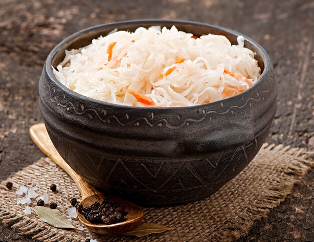 Sauerkraut with carrot in wooden bowl