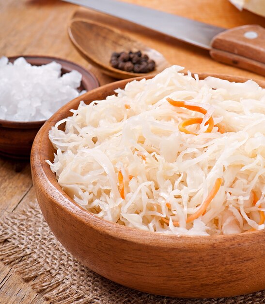 Sauerkraut with carrot in wooden bowl