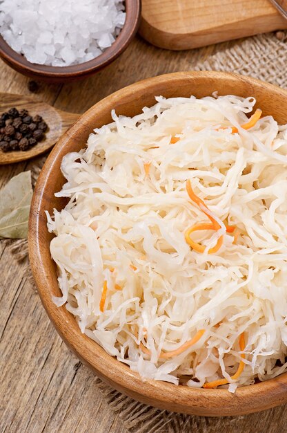 Sauerkraut with carrot in wooden bowl