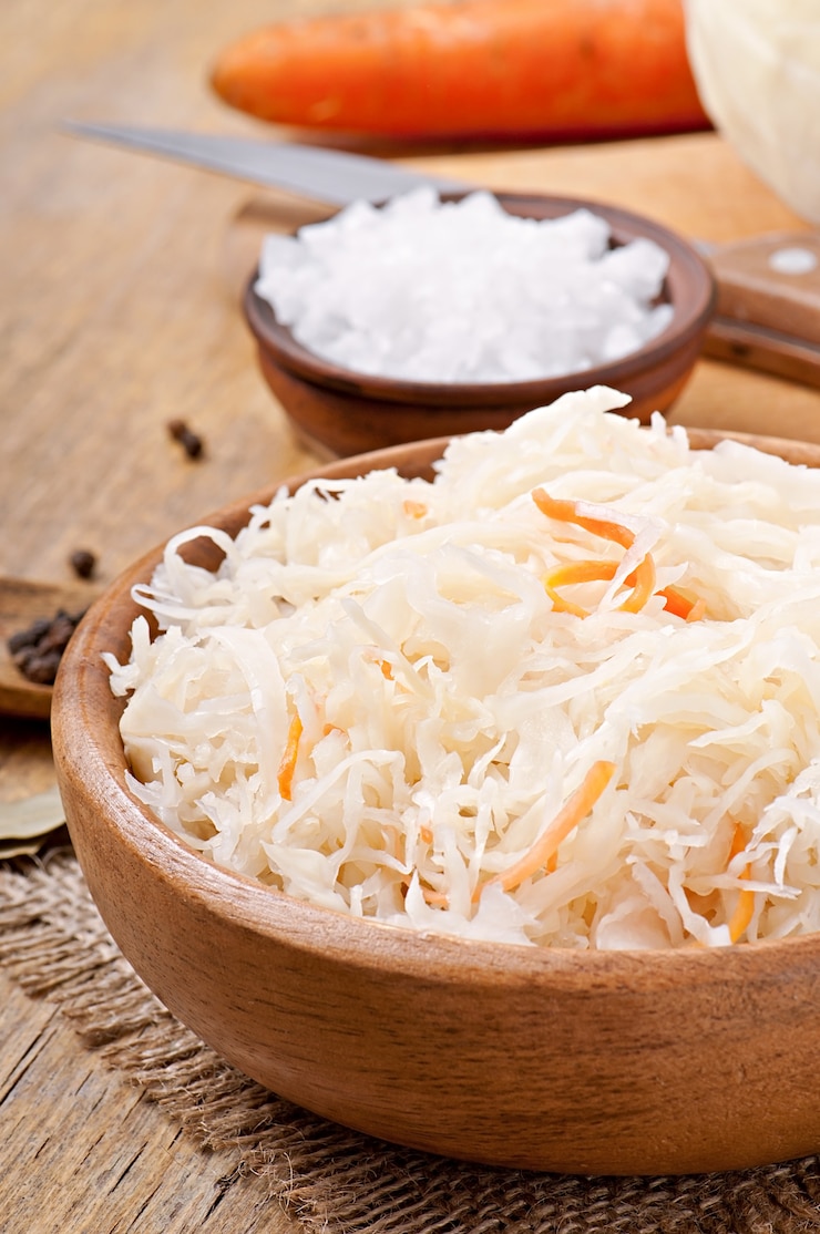 Free Photo sauerkraut with carrot in wooden bowl