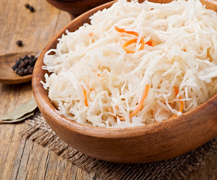 Free Photo sauerkraut with carrot in wooden bowl