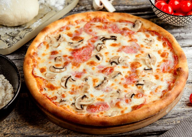 Sausage pizza with mushrooms on the table