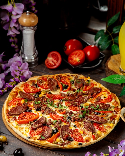 Free photo sausage pizza with tomato bell peppers and cheese