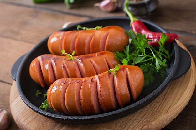 Sausages on the grill pan on the wooden table