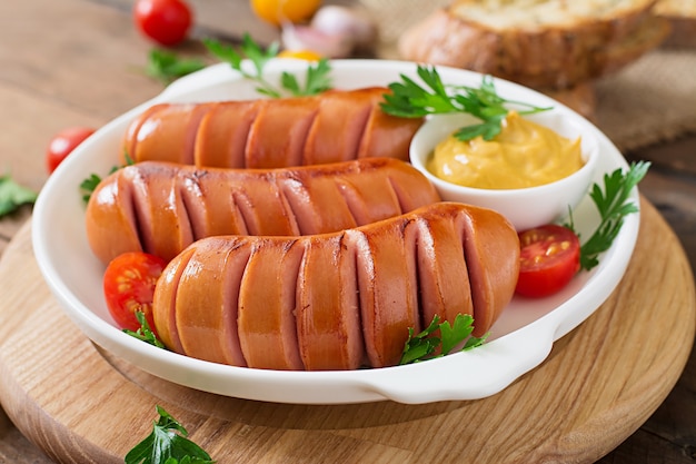 Sausages on the grill pan on the wooden table