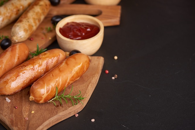 sausages and ingredients for cooking. Grilled sausage with the addition of herbs and and spices