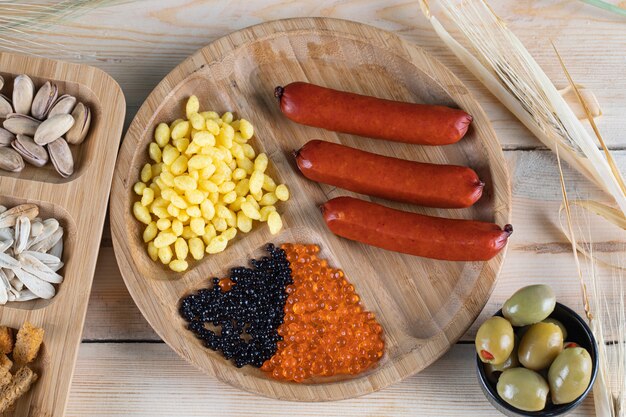 Sausages, marinated corn seeds and olives