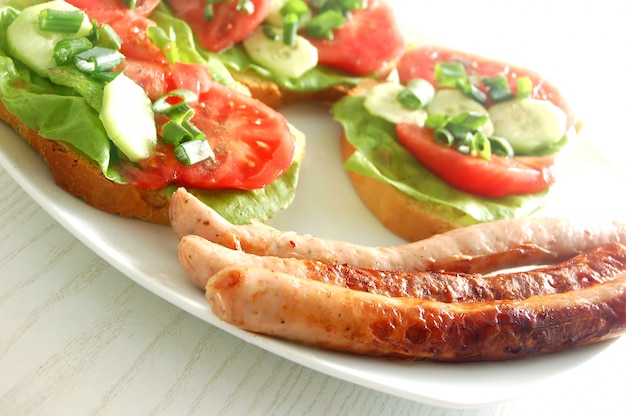 Free photo sausages with avocado and tomato