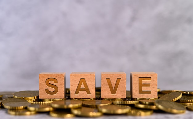 Free photo save word alphabet wooden cube letters placed on a gold coin