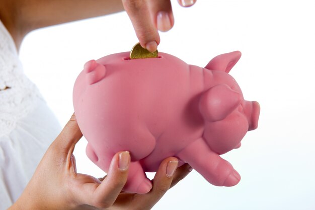 Saving, blonde young woman with a piggy bank