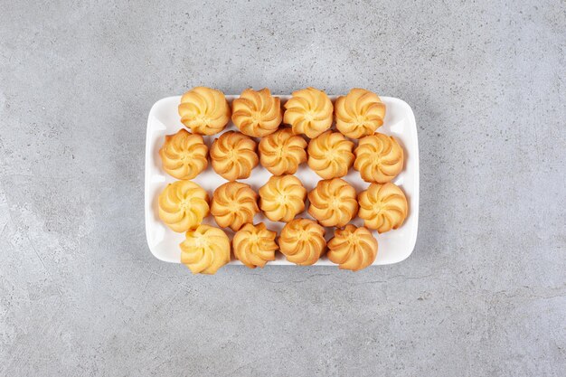 Savory cookies arranged on a white plate on marble background. High quality photo