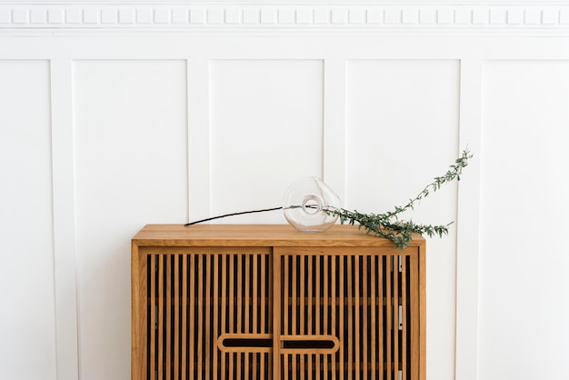 Free photo scandinavian vintage wood cabinet by a white wall