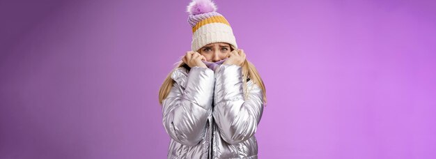 Free photo scared afraid insecure coward girl in cute hat glittering shiny jacket pull cloth face frightened