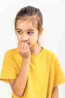 Free photo scared and anxious girl biting her fingernails on a white background isolated