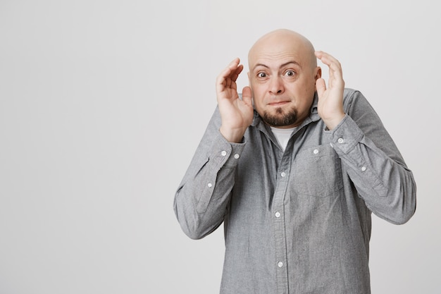 Scared bald man jumping from fear