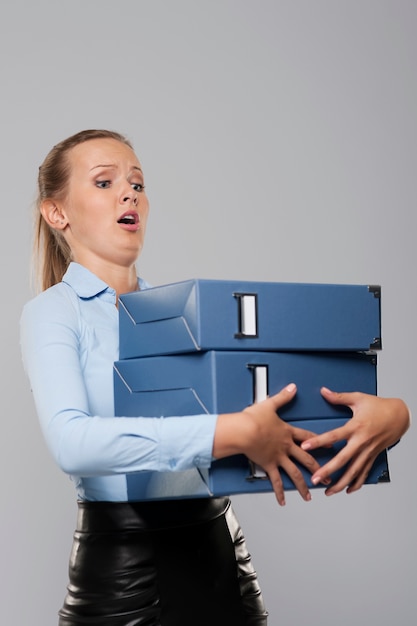 Scared businessman with heavy office documents