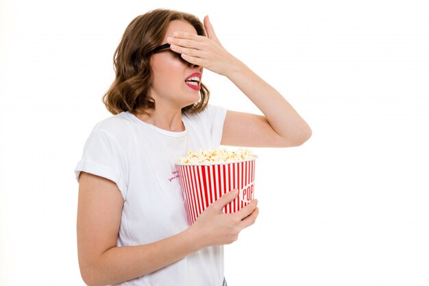 Scared caucasian woman holding pop corn watch film.