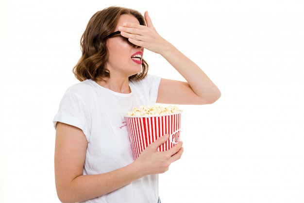 Scared caucasian woman holding pop corn watch film.