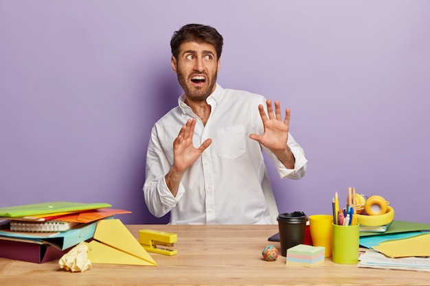 Scared employee sitting at the office desk