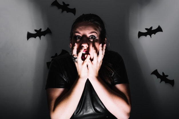 Foto gratuita ragazza spaventata in studio con pipistrelli