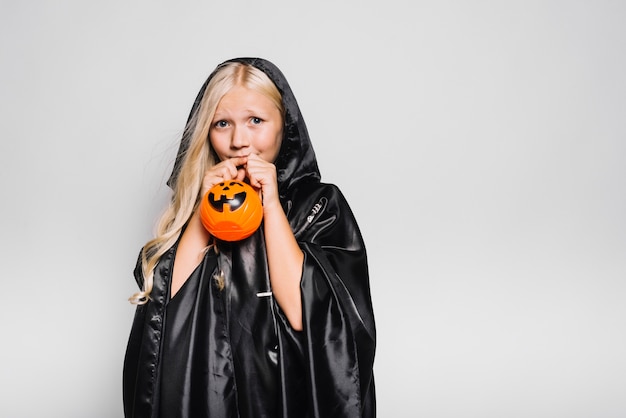 Free photo scared girl with trick or treat bucket