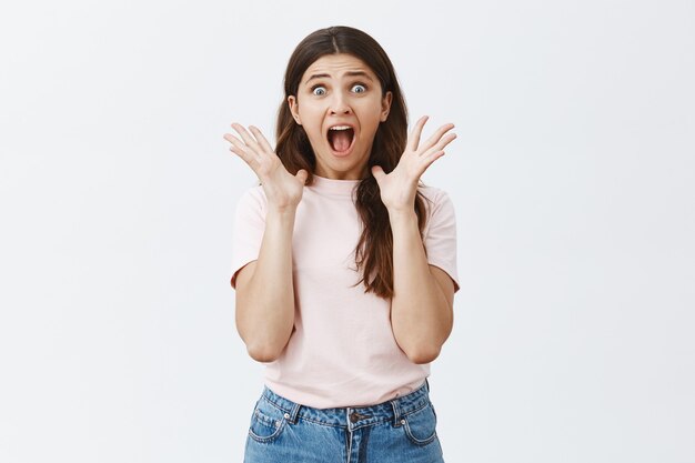 Scared and horrified young brunette posing