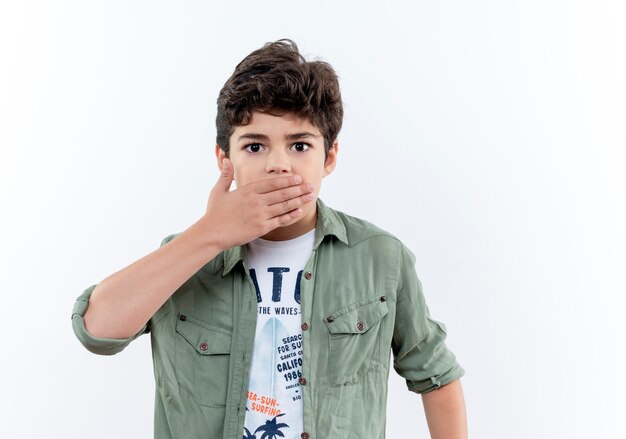 Scared little schoolboy covered mouth with hand isolated on white