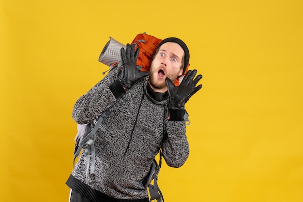 scared male hitchhiker with leather gloves and backpack