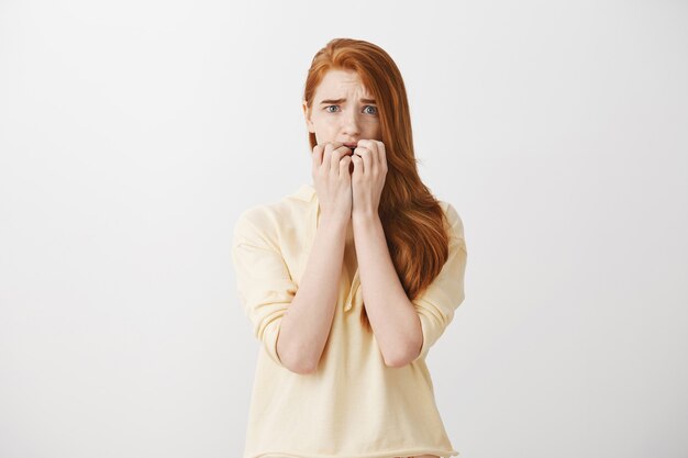 Scared timid redhead girl looking frightened