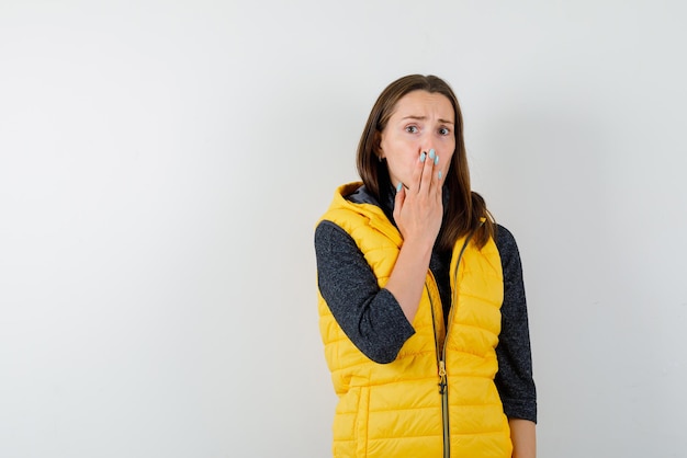 Free photo the scared woman is holding her hand on mouth on white background