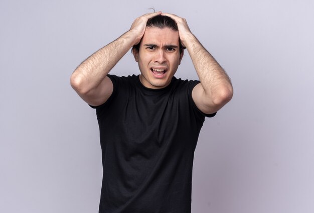 Scared young handsome guy wearing black t-shirt grabbed head isolated on white wall