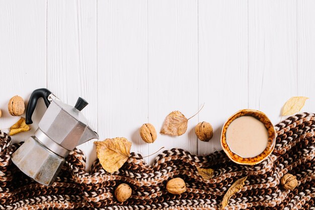 Scarf and leaves near coffee and nuts