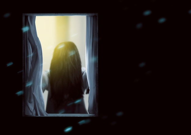 창에 서 있는 무서운 유령 여자. 할로윈 컨셉