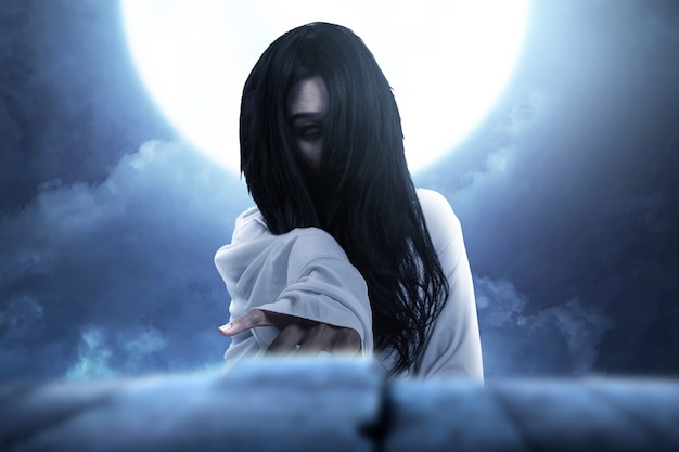 밤 장면 배경으로 서 있는 무서운 유령 여자. 할로윈 컨셉