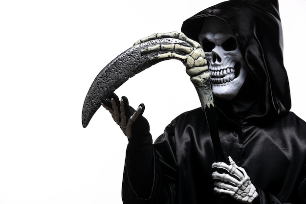 Free photo scary grim reaper in black clothes with scythe on white