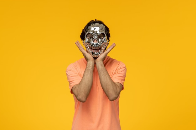 Free photo scary mask terrifying cute guy making a cute hand gesture
