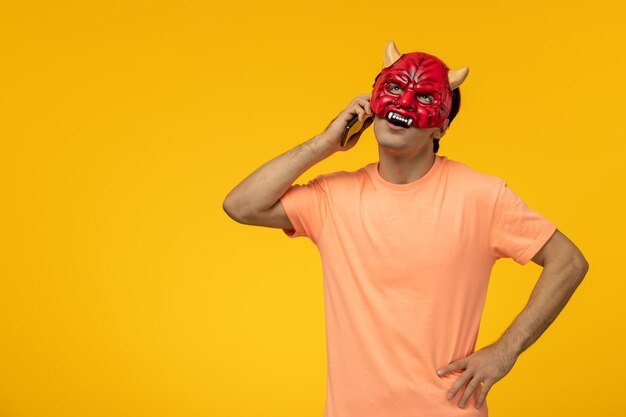 Scary mask young terrifying guy thinking in evil red mask