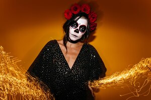 Scary tanned lady in wreath looking to camera sad vampire girl with black hair posing in halloween on sparkle background