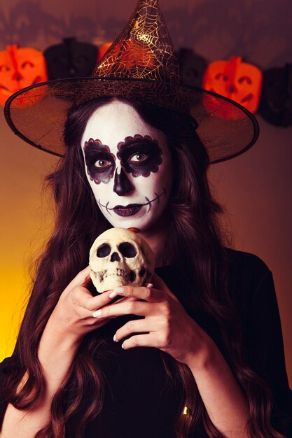 Scary witch holding skull