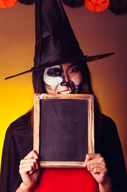 Scary witch holding slate