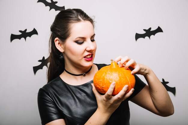 Scary woman posing with pumpkin