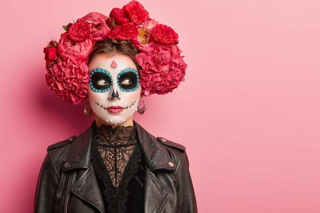 Scary woman with skull makeup, prepares for Day of Dead in Mexico