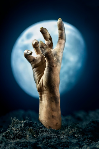 Scary zombie hand from the ground at night
